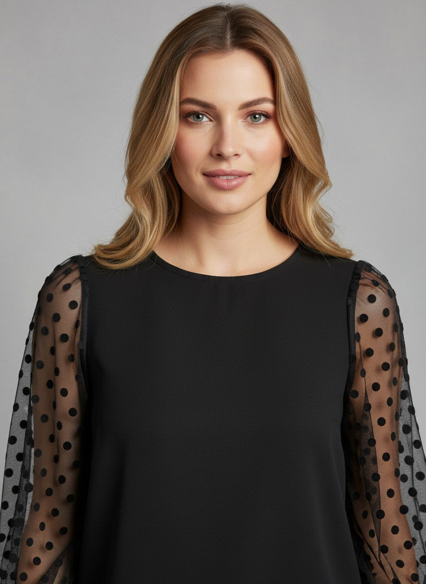 Черна блуза Benny Boutique с прозрачни ръкави от тюл на точки, носена от русокос модел.