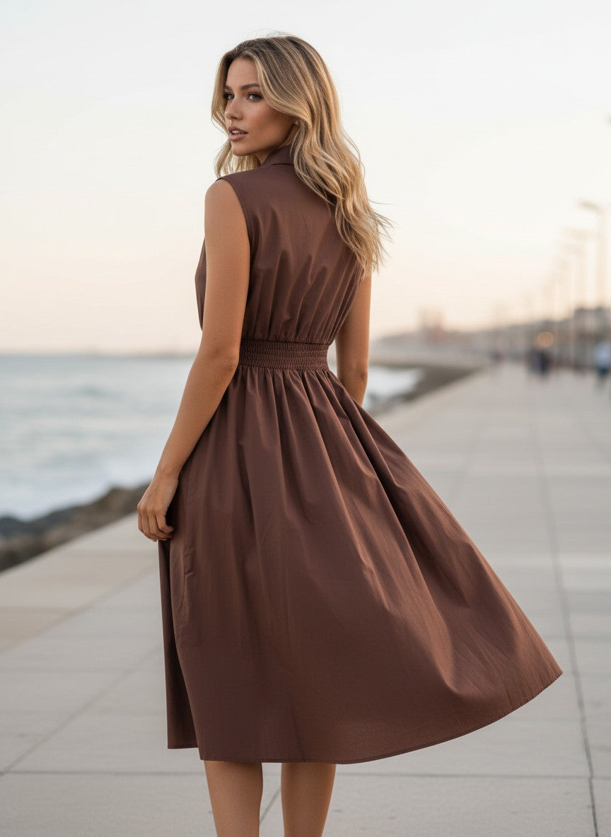 Benny Boutique кафява памучна миди рокля със структурирана яка, без ръкави и вталена талия, носена от жена.