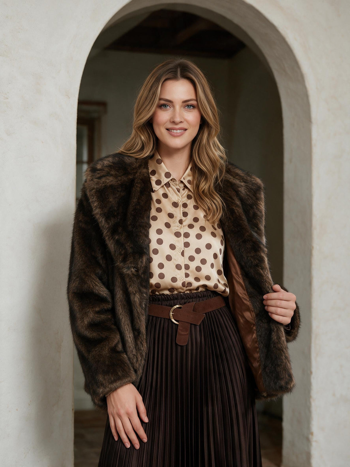 Дамско кафяво палто Benny Boutique от изкуствена кожа с широка яка и гладка подплата, облечено от модел в арковиден вход.