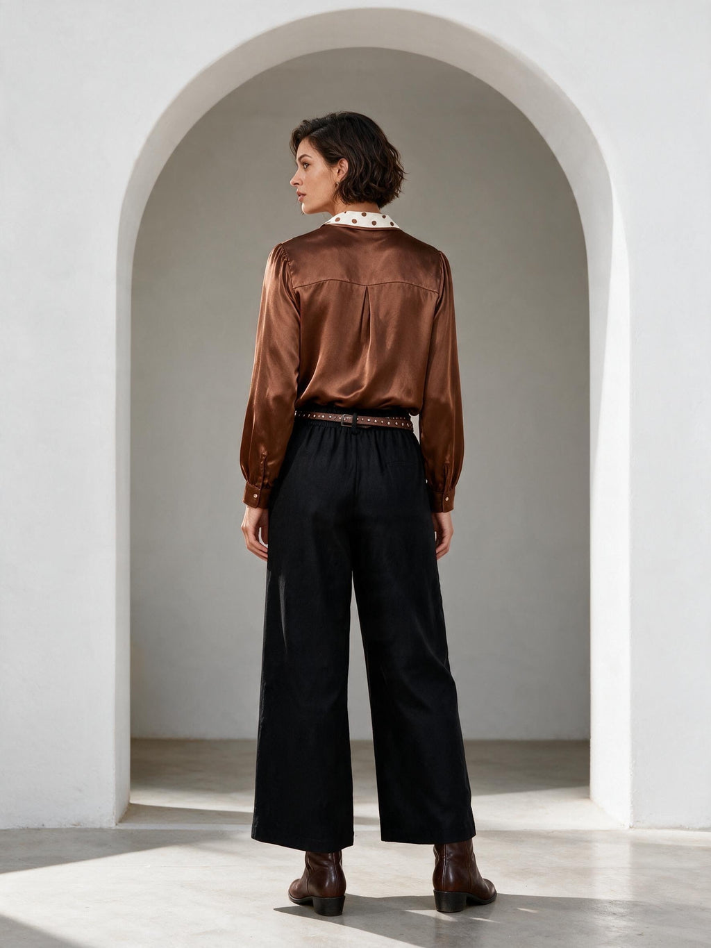 Кафява сатенена блуза Benny Boutique с яка на точки и обемни ръкави, съчетана с черен панталон.