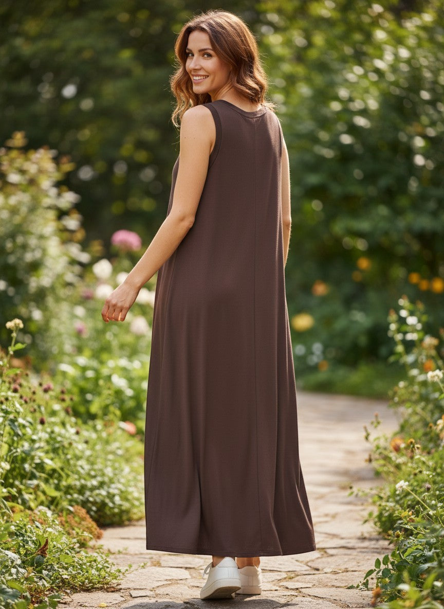 Кафява безръкавна макси рокля Benny Boutique с мек сатенен блясък, носена от жена в градина.