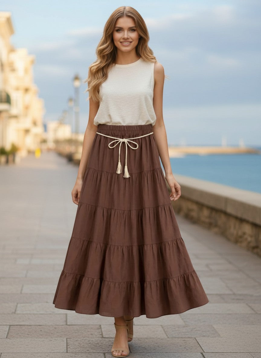 Benny Boutique кафява многопластова макси пола с връзка на талията, носена от жена на крайбрежна алея.