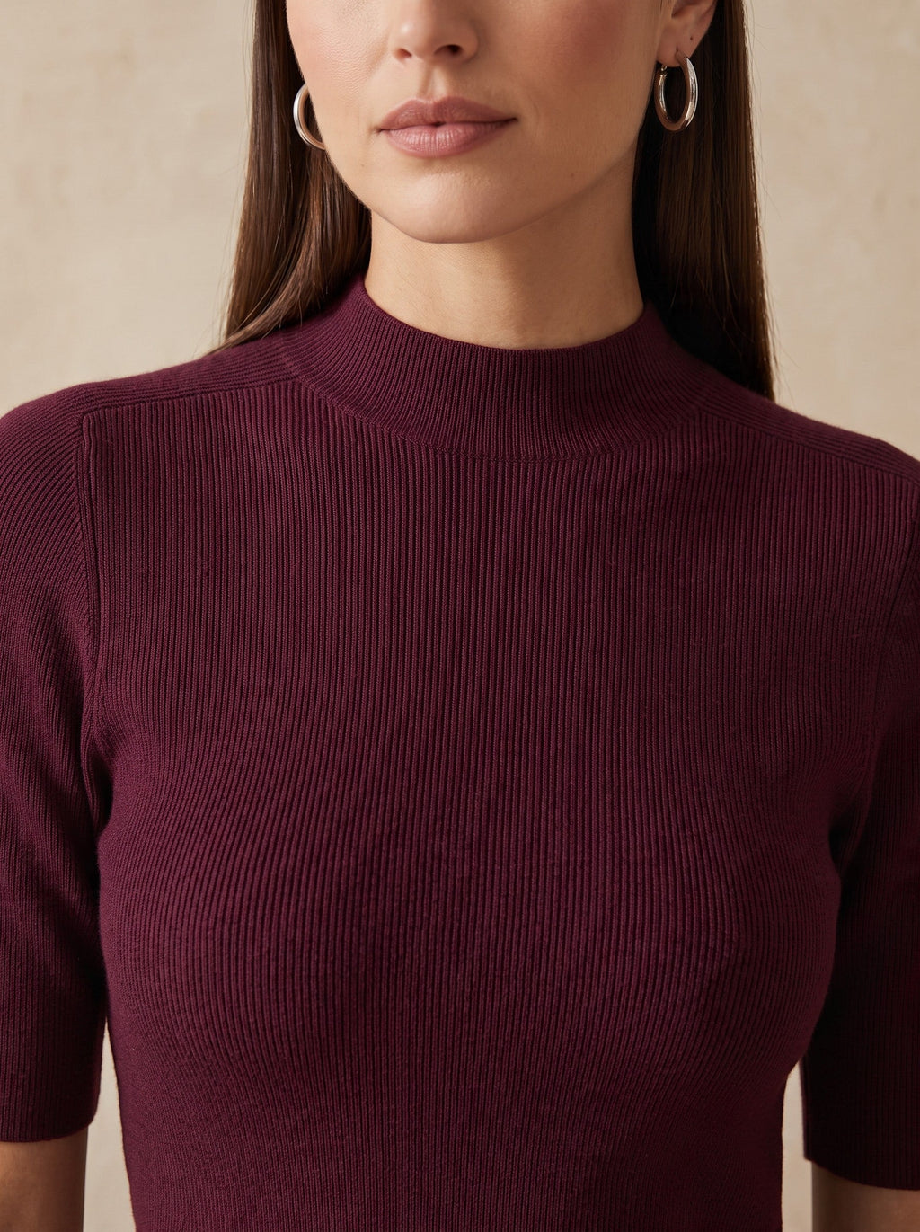 Бордо безшевна рипсена блуза Benny Boutique с къси ръкави и поло яка, носена от жена със сребърни обеци тип халки.