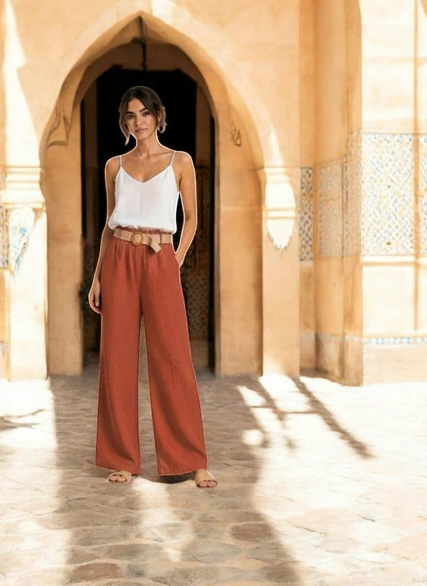 Benny Boutique coral red wide-leg linen-blend pants with a high waist and decorative belt. Model is wearing a white camisole.