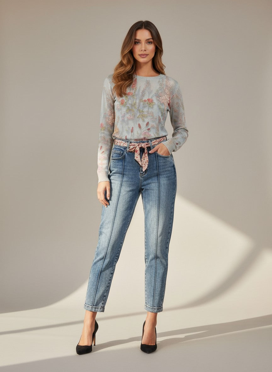 Сини дънки Benny Boutique с декоративен шев отпред и дължина до глезена, съчетани с пуловер на цветя и черни обувки на висок ток.