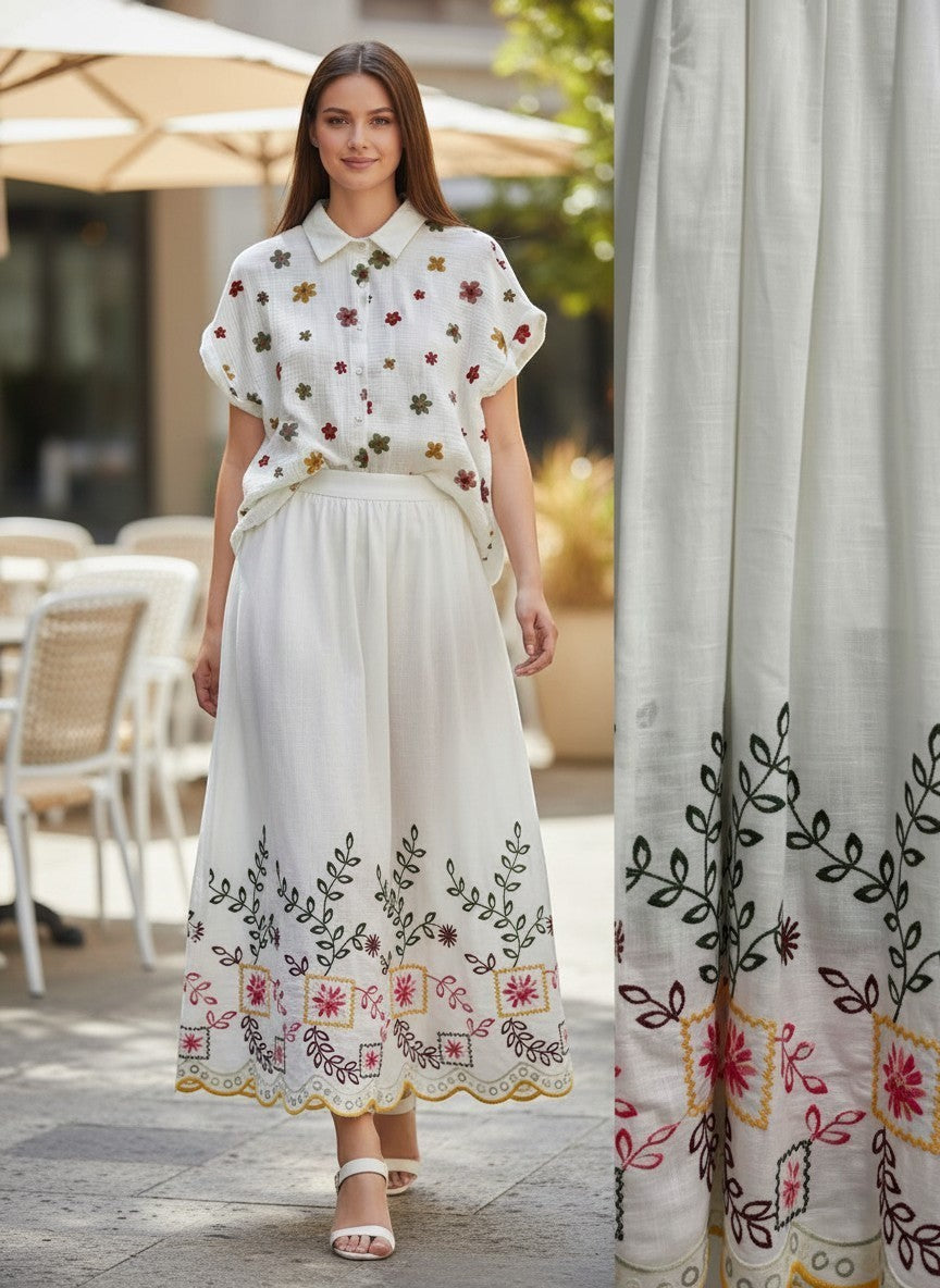 Benny Boutique бяла памучна миди пола с цветна фолклорна бродерия, стилизирана за летен бохо вид на градска улица.