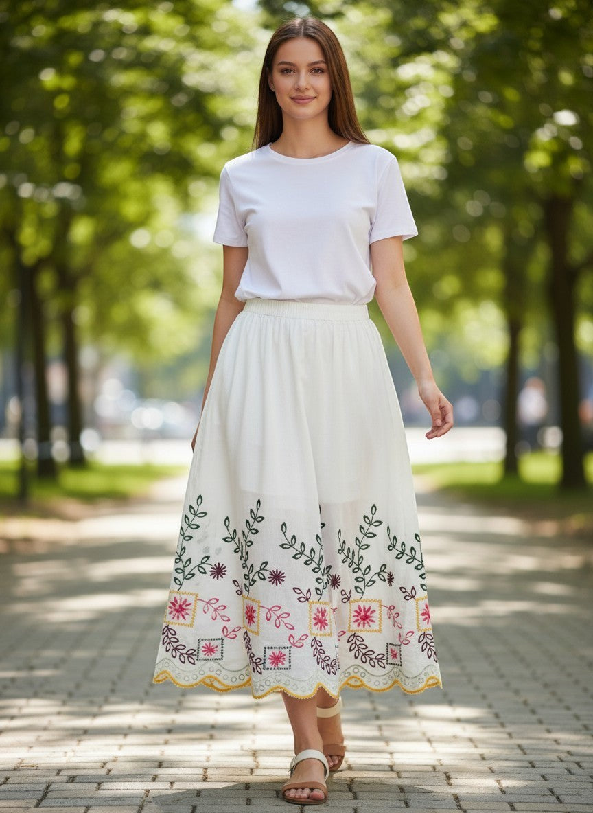 Benny Boutique бяла памучна миди пола с цветна фолклорна бродерия, стилизирана за летен бохо вид на градска улица.