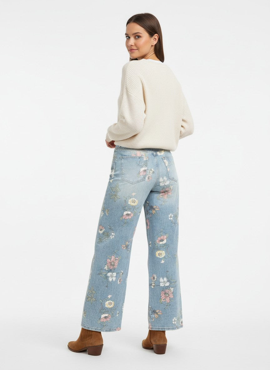 Сини дънки Benny Boutique с флорален принт и кристални декорации, носени от модел с бял пуловер.