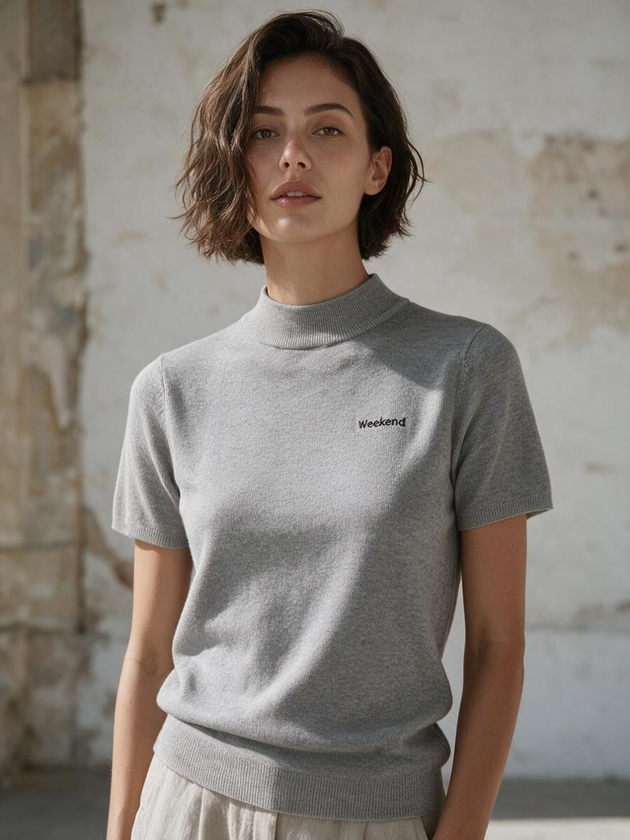 Сива рипсена плетена блуза Benny Boutique с къс ръкав, висока яка и бродерия „Weekend“ на гърдите.
