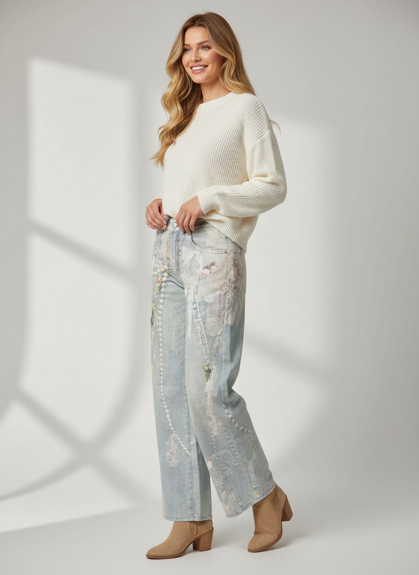 Светлосини дънки Benny Boutique с декоративен принт от бижута и мъниста, представени върху усмихната жена, облечена в бял пуловер.
