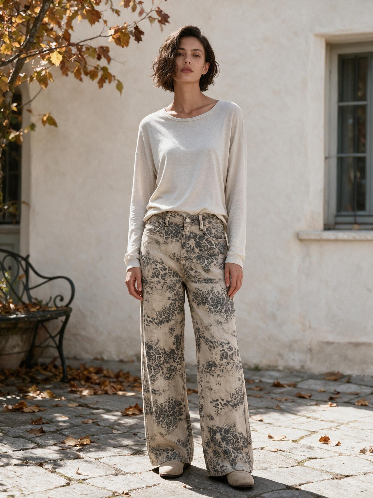Широки дънки от Benny Boutique с избледнял сиво-бежов леопардов принт, облечени от жена на открито.