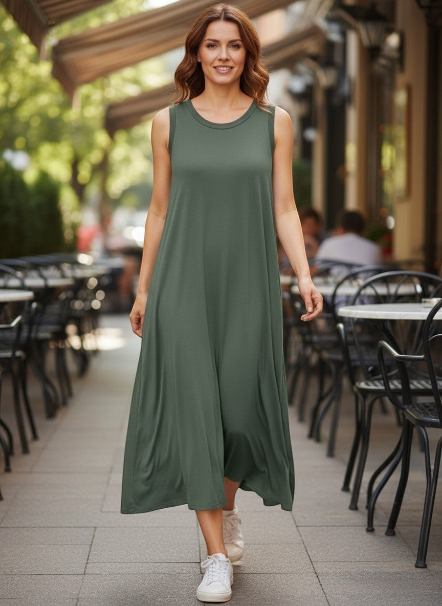 Оливково-зелена безръкавна макси рокля Benny Boutique с мек, летящ силует, носена от жена на градска улица.