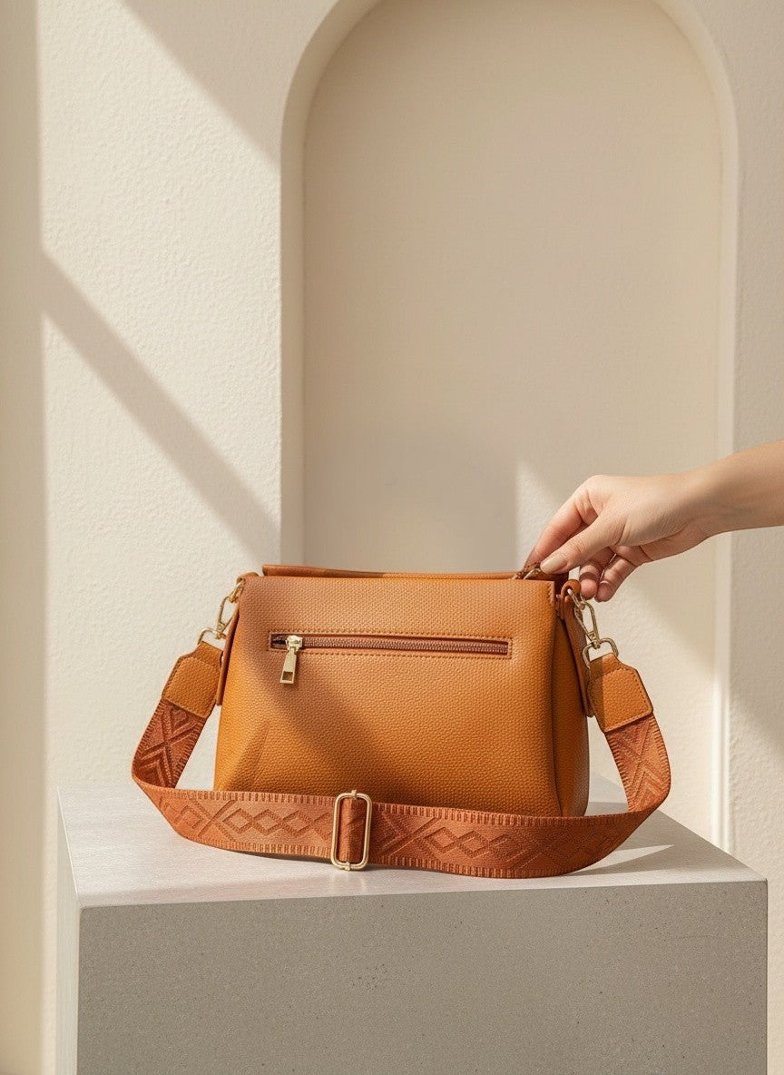 Кафява текстурирана кросбоди чанта от еко кожа на Benny Boutique с широка шарена презрамка и златисти ципове.
