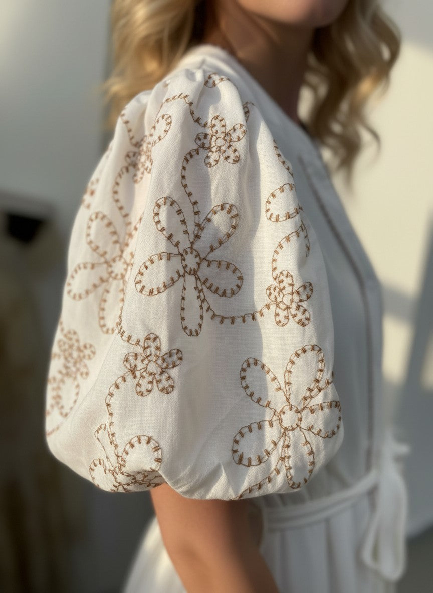 Бяла макси рокля Benny Boutique с буфан ръкави и кафява флорална бродерия, изработена от мека смес от памук и вискоза.