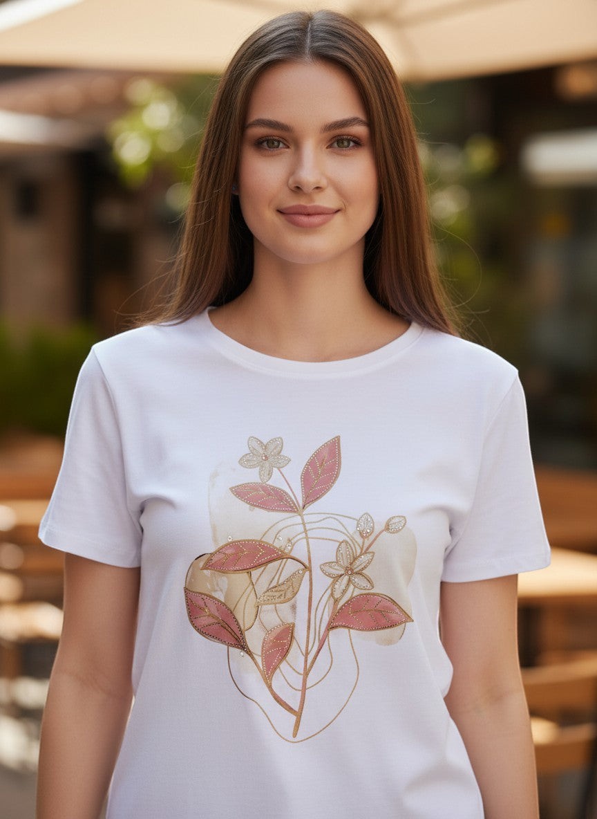 Бяла памучна тениска на Benny Boutique с деликатен розово-златист флорален принт, носена от млада жена.