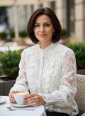 Benny Boutique бяла прозрачна блуза с флорален релеф, къдри и предно закопчаване с копчета, носена от жена в кафене.