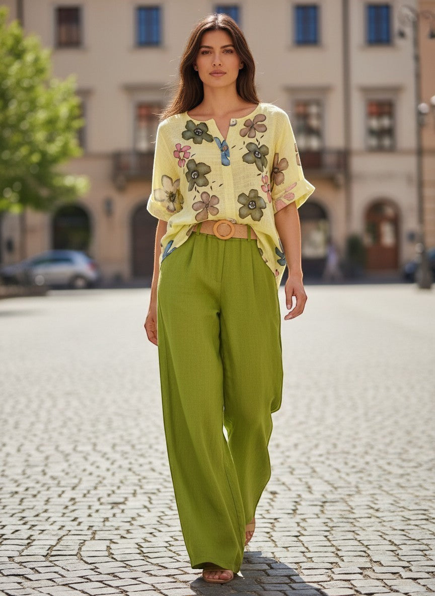 Жълта блуза с флорален принт на Benny Boutique с къси ръкави и разкроен силует, носена от модел на градски площад.