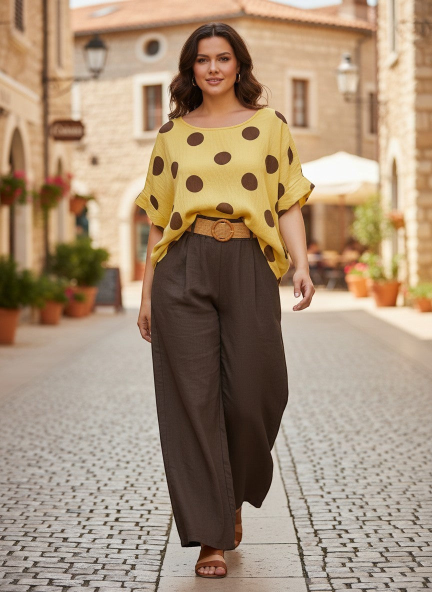 Жълта блуза от Benny Boutique с кафяви точки, със свободна кройка, дишаща вискозна смес, носена с кафяви панталони.
